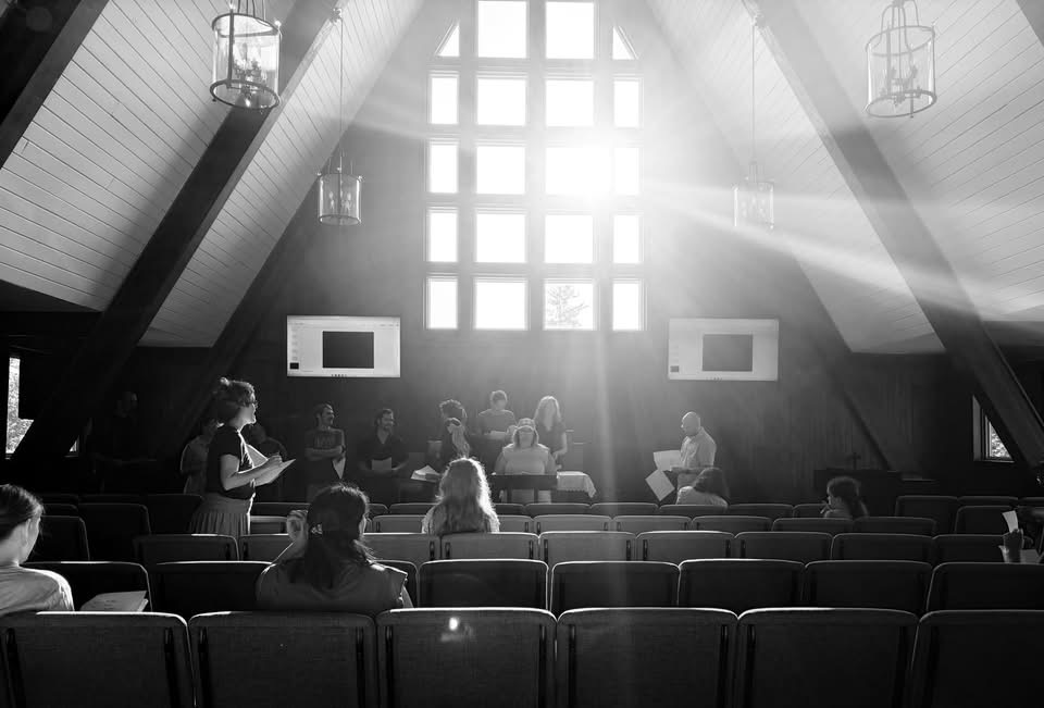 Cast and creative team gathered for rehearsal in a sunlit theater